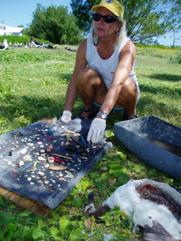 The author, Patty Greene, sorts through the 306 pieces of plastic debris found in a Laysan Albatross chick on Green Island.  Photo: Claire Johnson/NOAA